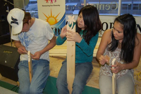 Kids from the Youth Centre working on boards for the community fence